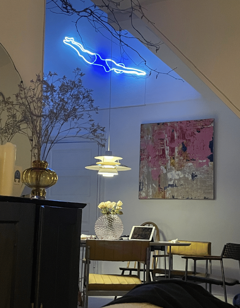 Neonskilt med den ikoniske engelske svømmer i en stue